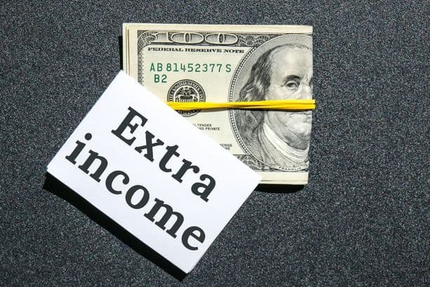 Cash bundle with card reading 'Extra income'